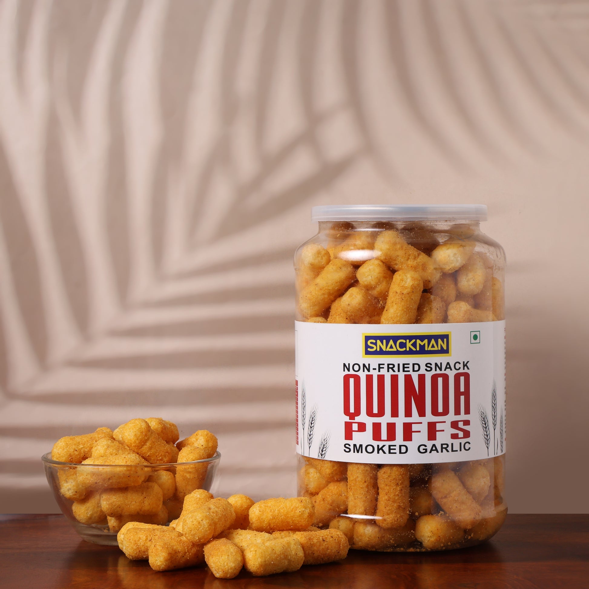 Jar of Snackman Quinoa Puffs Smoked Garlic on a wooden surface with a beige background