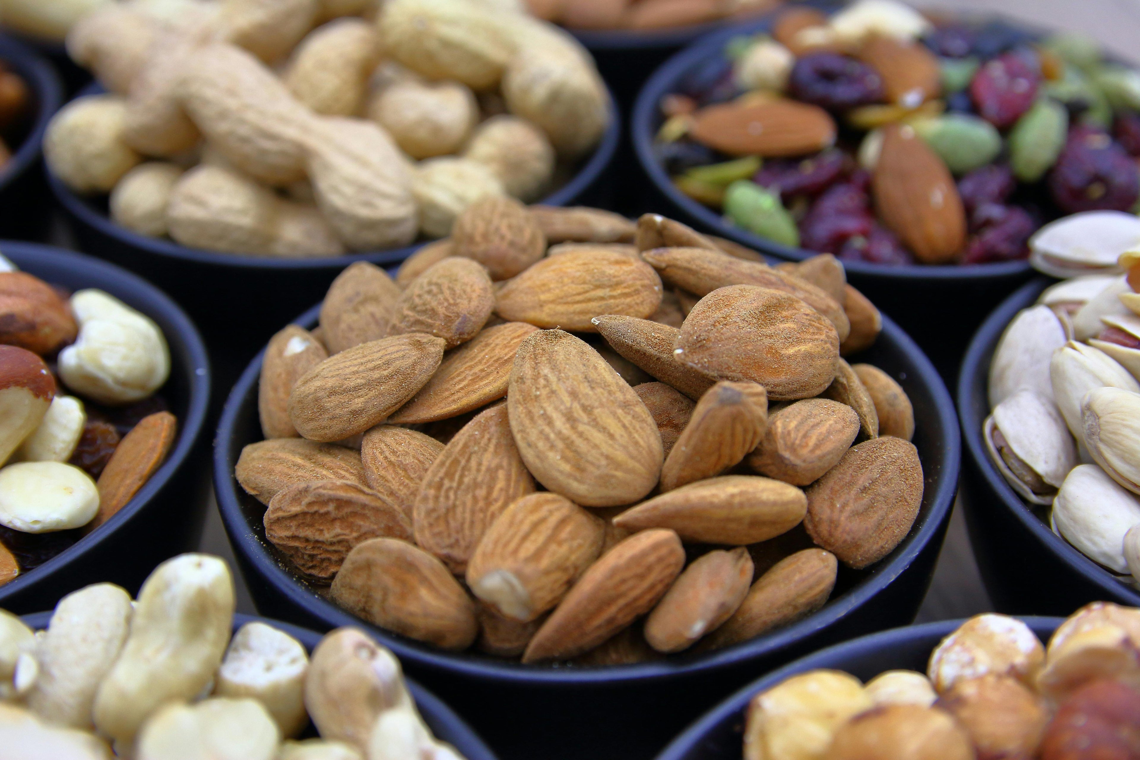 Premium dry fruits in bowl including almonds, cashews, peanuts, seedmix & pistachios in deep focus for healthy snacking